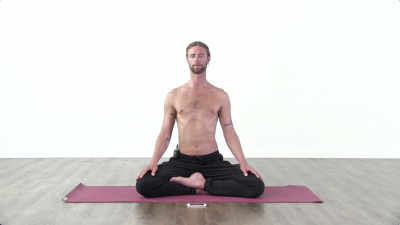 Yogi is practising yoga on a burgundy coloured yoga mat on white background