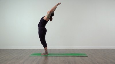 Yoga teacher performing yoga posture on green yoga mat on white background